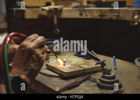 Händen der Handwerkerin mit Lötlampe Stockfoto