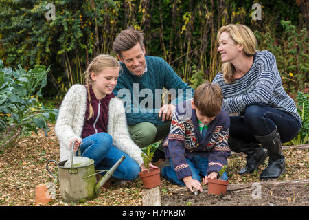 Attraktive, erfolgreiche und glückliche Familie, Mann, Frau, Mädchen und jungen Kind, Mutter, Vater, Sohn und Tochter zusammen im Garten Stockfoto