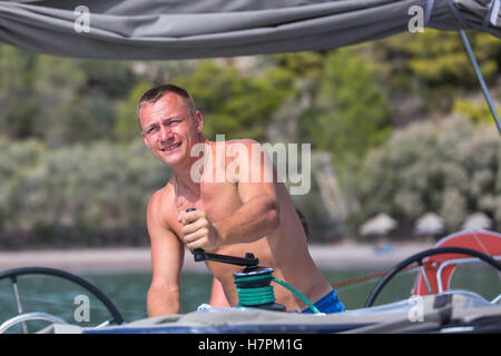 Segeln, Man zieht Seile, Wicklung Blätter herum winden. Luxus Yacht Boot. Stockfoto