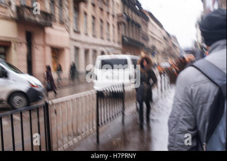 Straße mit Fußgängern und Fahrzeugen an einem regnerischen Tag Stockfoto