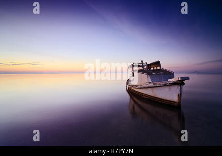 Schöner Hintergrund von Himmel und Meer bei Sonnenaufgang mit ein wenig altes Boot aufgegeben in das Mar Menor, Spanien Stockfoto