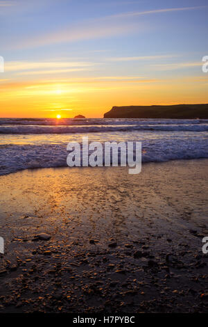 Sonnenuntergang am Polzeath Strand - gegen Wasser mit langsamen Verschlusszeit zu Bewegungsunschärfe Wirkung verleihen der Wellen Stockfoto