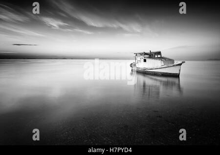 Schöner Hintergrund von Himmel und Meer bei Sonnenaufgang mit ein wenig altes Boot aufgegeben in das Mar Menor, Spanien Stockfoto