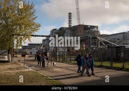 Arbeiter die neue sichere Entbindung vorbei an den zerstörten Reaktor Nr. 4 mit seiner alten einschließenden Sarkophag. Kernkraftwerk, Ukraine Stockfoto