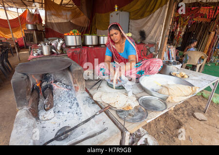 Eine Frau macht Chapattis auf Streetside in einer Straße in Pushkar, unter Verwendung der traditionellen Heizplatte Stockfoto