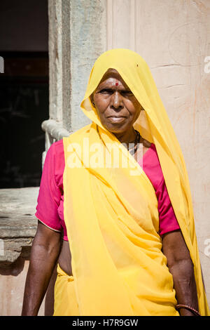 Eine Frau mittleren Alters aus Indien trug einen gelben Sari und rotes Hemd, Jaipur Indien Stockfoto