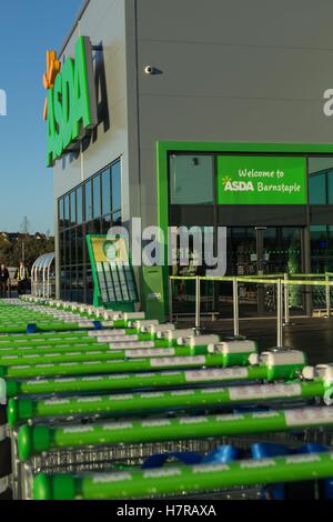 Außenansicht des Asda-Ladens, komplett mit einer Reihe von Einkaufswagen in Barnstaple, Devon, Großbritannien Stockfoto