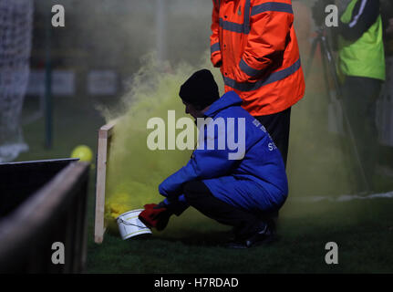 Verwalter versuchen, mit einer Fackel zu behandeln, nachdem es beim ersten Vorrundenspiel am Merseyrail Community Stadium, Southport Emirates FA Cup auf das Spielfeld geworfen wurde. Stockfoto