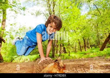 Junge, springen über das Protokoll im Sommer Wald Stockfoto