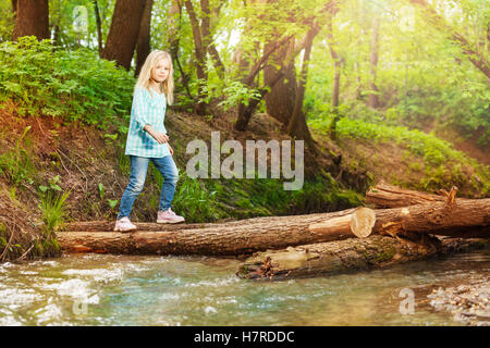 Kleines Mädchen Log-Brücke im Wald Stockfoto