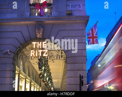 LONDON WEIHNACHTEN BLUR BUS das Ritz Hotel in der Dämmerung mit Weihnachtsschmuck Union Jack Flagge und verschwommenes vorbei an traditionellen roten Bus Piccadilly London UK Stockfoto