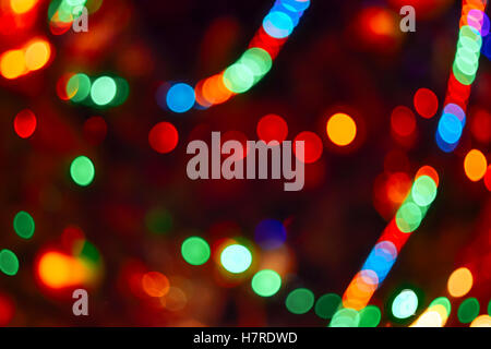 Christmas Lights Hintergrund. Verschwommene elektrische Girlande am Weihnachtsbaum. Rot, grün, gelb, orange und blau leuchten Stockfoto