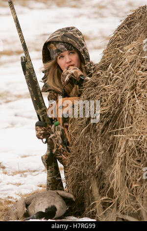 Weibliche Wasservögel Jäger mit Gewehr und Rusty Yellow Lab Stockfoto