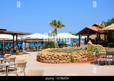 Brunnen auf einem kleinen Platz, umgeben von Bars und Restaurants mit Blick auf das Meer, Stalis, Kreta, Europa. Stockfoto