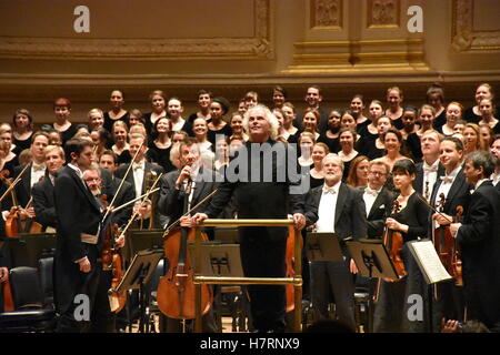 Datei - Simon Rattle, Dirigent der Berliner Philharmoniker, stehend vor dem Orchester in der Carnegie Hall in New York, USA, 21. November 2015. Die Berliner Philharmoniker beginnen ihre Nordamerika-Tour am Mittwoch, die letzte Tour des scheidenden Dirigenten Simon Rattle. Bis 23. NOvember spielen die Musiker elf Konzerte an sieben Standorten, darunter New York, Boston, Toronto und Los Angeles. Foto: CHRIS MELZER/dpa Stockfoto