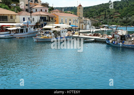 Vathi, Griechenland, 11. Mai 2013: Landschaft mit Kirche, Liegeplatz und Fischerboot im Hafen von Vathi auf der Insel Meganisi. Ionisches Meer Stockfoto