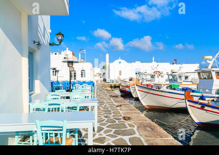 Taverna Tabellen und traditionelle Fischerboote im Hafen von Naoussa, Insel Paros, Griechenland Stockfoto