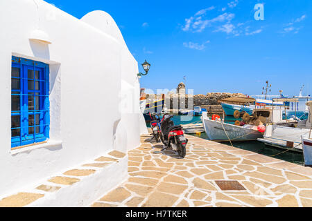 Hafen von NAOUSSA, PAROS Insel - 20. Mai 2016: Roller Parkplatz vor typisch weißen Griechische Kirche in Naoussa Hafen, Insel Paros, Kykladen, Griechenland. Stockfoto