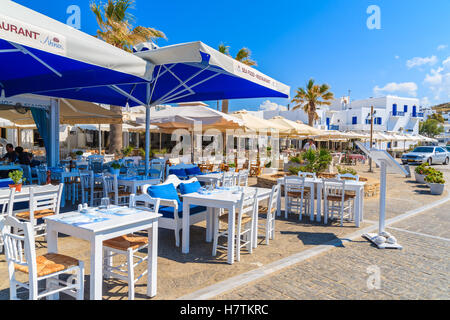 Insel PAROS, Griechenland - 20. Mai 2016: Restauranttische warten auf Touristen in Naoussa Hafen, Insel Paros, Griechenland. Stockfoto