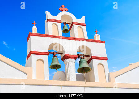 Weiße Kirchturm mit drei Glocken vor blauem Himmelshintergrund im Dorf Oia, Santorin, Griechenland Stockfoto