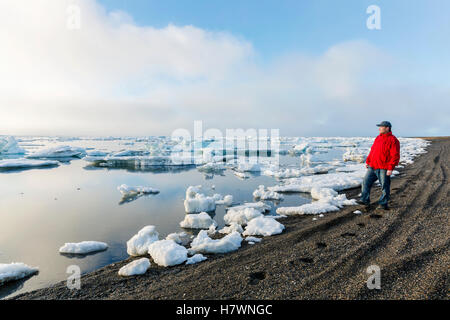 Ein Mann an der Küste des arktischen Ozeans, Blick auf die untergehende Sonne durch dichten Nebel, Barrow, North Slope, Arktis, Alaska, USA, Sommer Stockfoto