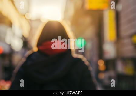 Bewegungsunschärfe Bild unkenntlich weibliche Person von hinten auf der Straße in kalten Herbstnachmittag Stockfoto