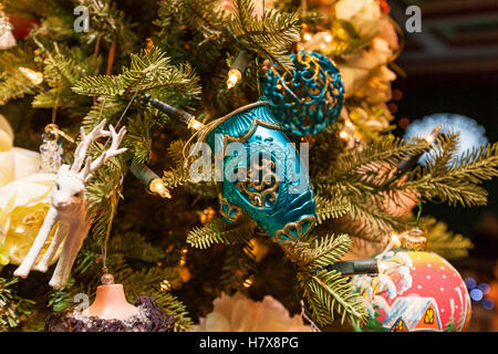 Weihnachtsbaum mit der Dekoration. Blue Christmas Cup, Kugeln, Hirsch Spielzeug und Girlanden auf einem Weihnachtsbaum Zweig. Stockfoto
