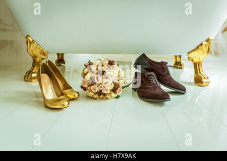 Hochzeit-Hintergrund. Vintage Hochzeit Hintergrund mit Bouquet, in der Nähe von golden weiblich und braun männliche Schuhe der weißen Wanne. Stockfoto