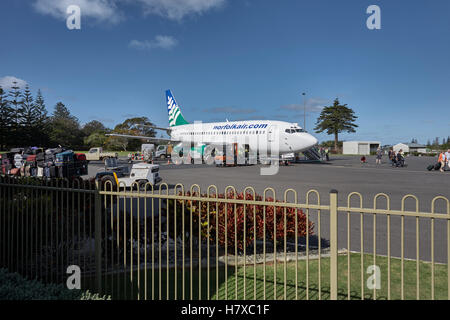 Passagiere, die aus einer Boeing 737 von Norfolk Air aussteigen und ihre Gepäckstücke am Norfolk Island Airport, Norfolk Island, Australien, verladen werden möchten Stockfoto