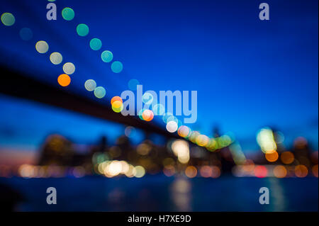 Die Skyline von New York mit Brooklyn Bridge und Downtown Manhattan aus malerischen Blick auf den Sonnenuntergang über den East River defocus Stockfoto