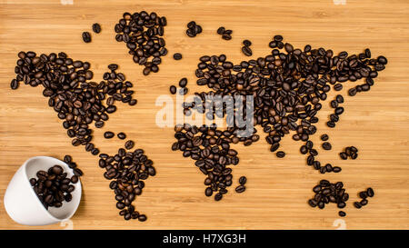 Karte der Welt von gerösteten Arabica Kaffeebohnen Handauflegen Bambus Holz strukturierten Hintergrund Stockfoto