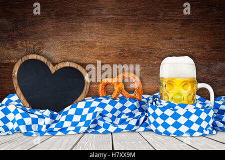 Oktoberfest-Hintergrund mit Bier Becher bayerische Flagge und leer in Herzform Tafel Stockfoto