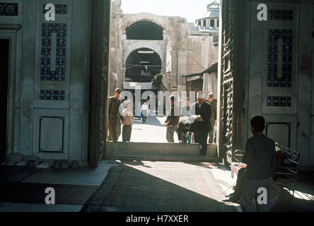 Besucher betreten die Umayyaden-Moschee in der syrischen Stadt Damaskus, Syrien März 1963. | Stockfoto