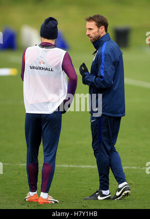 Englands Interimstrainer Gareth Southgate (rechts) mit Adam Lallana (links) während einer Trainingseinheit im St. Georges Park, Burton spricht. Stockfoto