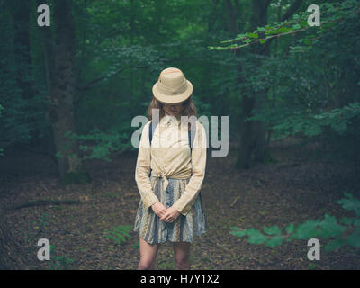 Eine junge Frau, die einen Safari Hut steht im Wald Stockfoto