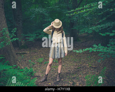 Eine junge Frau, die einen Safari Hut steht im Wald Stockfoto