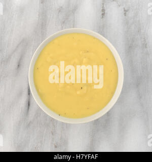 Draufsicht der Cheddar-Kartoffel-Suppe in eine Schüssel auf einem Marmor Tischplatte. Stockfoto