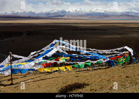 Bunte Gebetsfahnen, hinter Mt. Gurla Mandhata, 7728m, und der heilige Manasarovar See. Tibet, China. Stockfoto