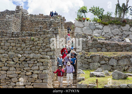 Machu Picchu, einer Inka Zitadelle, die hoch in den Anden in Peru eingestellt. Touristen gehen unter den Burgmauern. Stockfoto