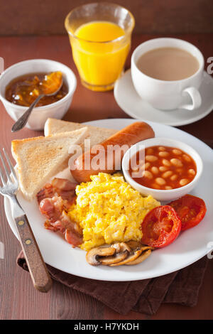 englisches Frühstück mit Rührei, Speck, Würstchen, Bohnen, Tomaten Stockfoto