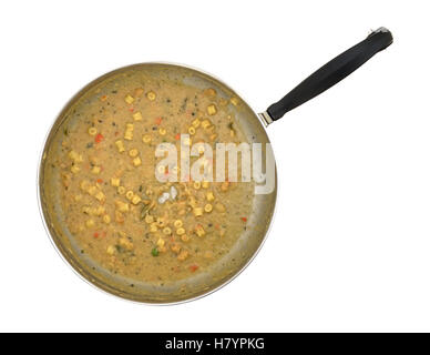 Draufsicht auf eine Pfanne mit übrig gebliebenen Suppe im unteren Bereich auf einem weißen Hintergrund. Stockfoto