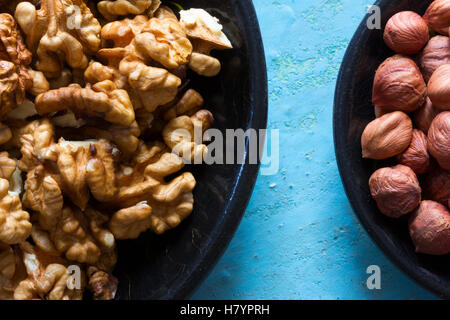 Ein Teil der Runde Holzplatten mit den geräumten Walnüsse und Haselnüsse auf einem blauen Hintergrund. Stockfoto