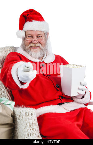 Santa Claus mit Popcorn während des Fernsehens Stockfoto