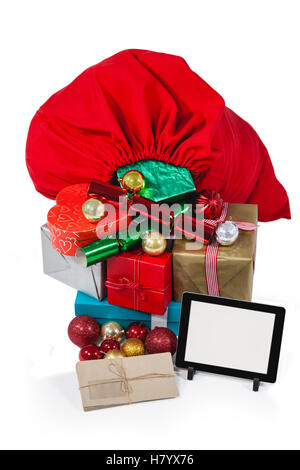 Santa Tasche gefüllt mit Geschenken überrascht und digital-Tablette Stockfoto