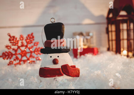 Schneemann und Weihnachtsdekorationen auf Kunstschnee Stockfoto