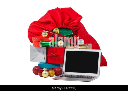 Santa Tasche gefüllt mit Geschenken überrascht und laptop Stockfoto