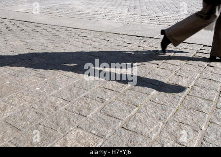 Walker Schattenwurf auf dem Bürgersteig Stockfoto
