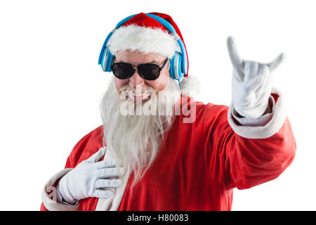 Santa Claus mit Hand yo melden Sie beim Musikhören über Kopfhörer Stockfoto