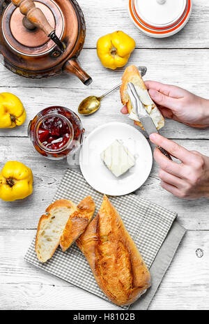 Hände, die Vorbereitung für das Frühstück mit Brot, Butter und Marmelade für Tee Stockfoto