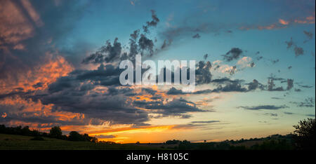 Panorama Sonnenuntergang am bewölkten Himmel über ländliche Landschaft Stockfoto